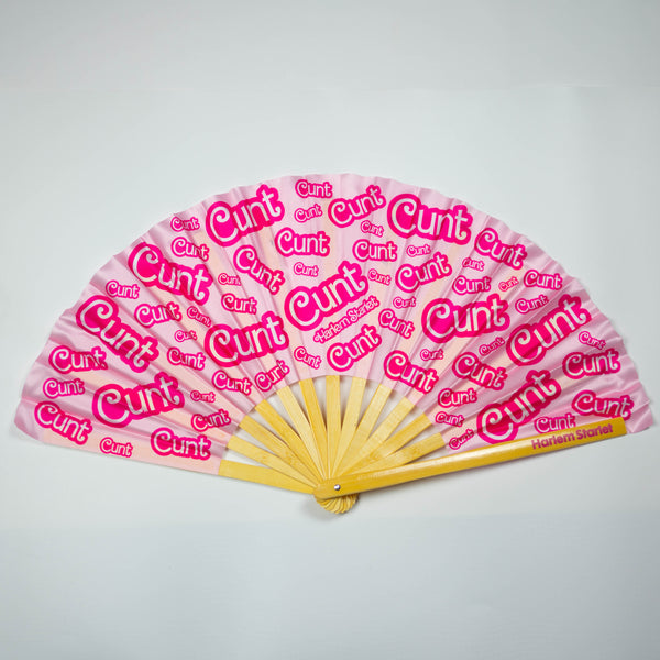 A Bamboo & Silk handheld folding fan that is Pink with a Hot Pink Cunt print pattern is spread open on a white background.