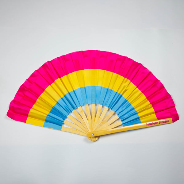 A Bamboo & Silk handheld folding fan that is in a Pansexual flag pattern in Pink, Yellow and Blue is spread open on a white background.