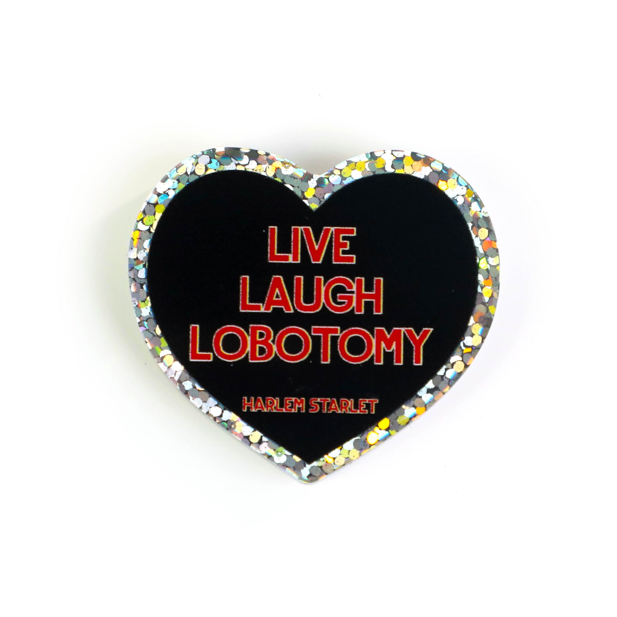 Heart pin with a black background, featuring red text that says "Live, Laugh, Lobotomy". Edges are silver with multicolored glitter. Mental Health Pins.
