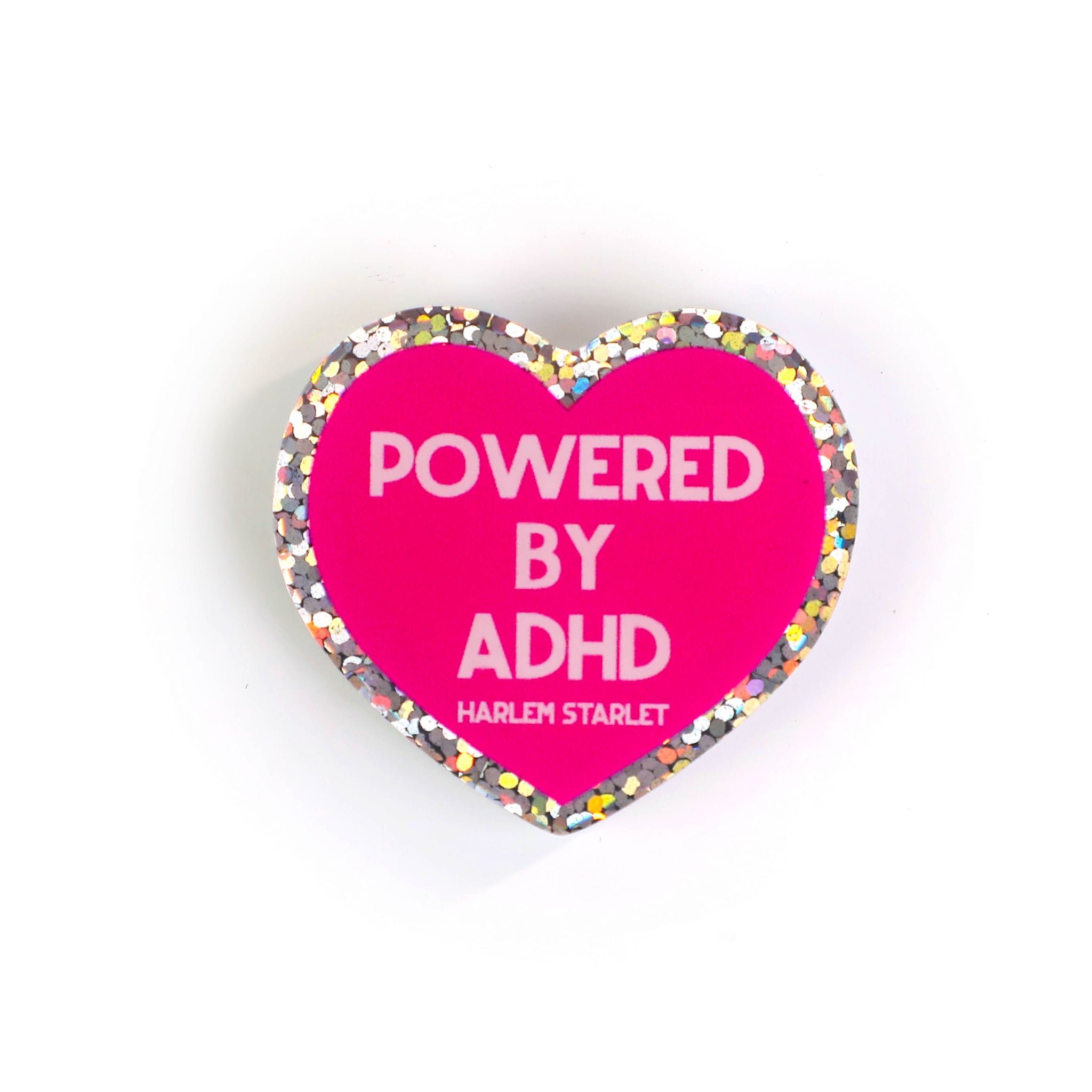 Heart pin with a hot pink background, featuring light pink text that says "Powered by ADHD!". Edges are silver with multicolored glitter. Neurodivergent Pride Pin.