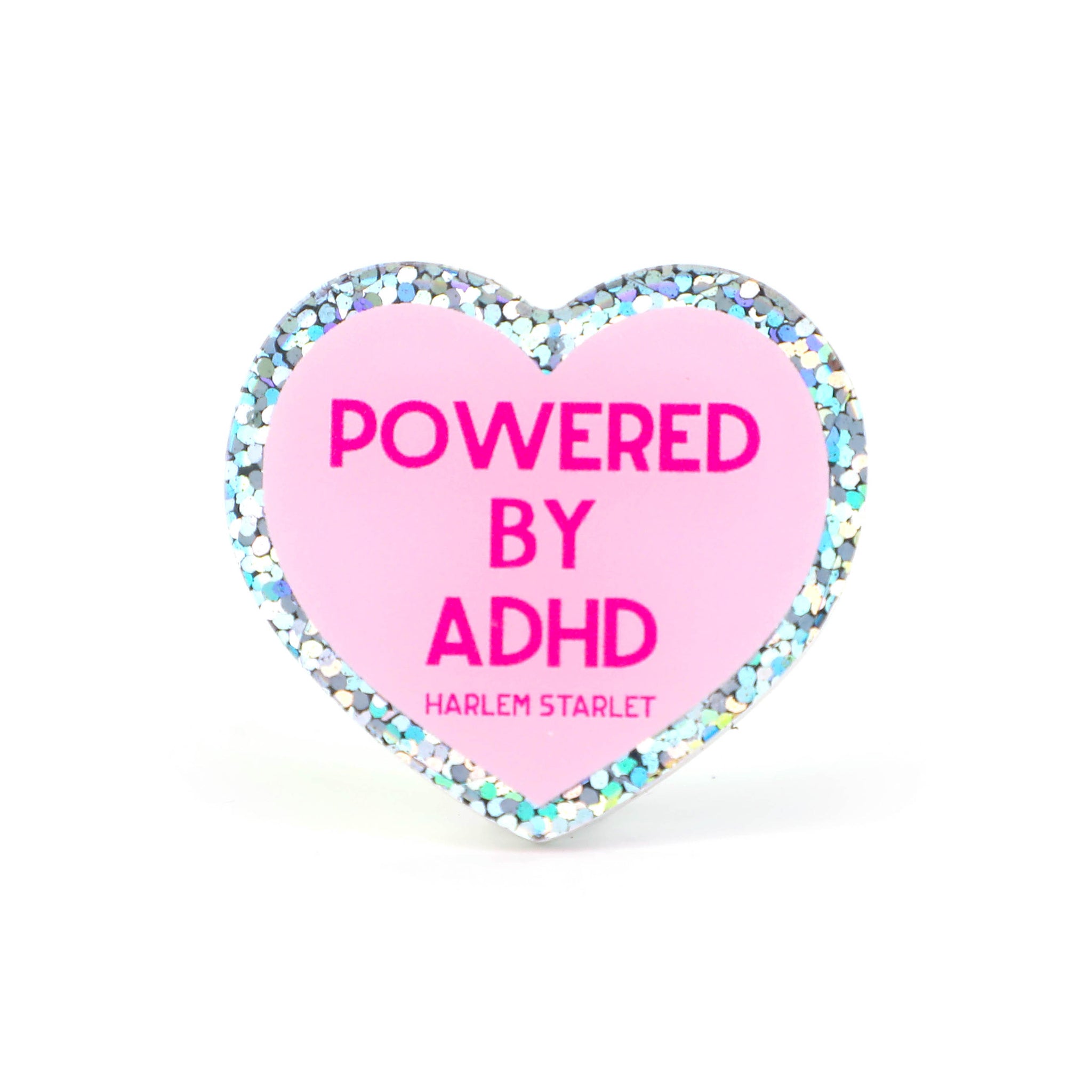 Heart pin with a pink background, featuring hot pink text that says "Powered by ADHD!". Edges are silver with multicolored glitter. Neurodivergent Pride Pin.